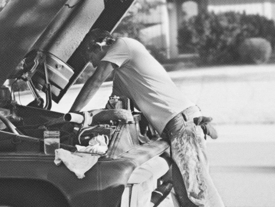 Mechanic leaning into an open engine bay